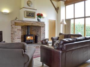 a living room with couches and a brick fireplace at The Hayloft-W42941 in Burn