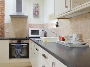 a kitchen with a sink and a microwave at The Hayloft-W42941 in Burn