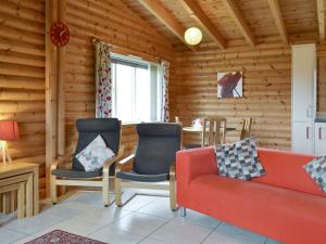 a living room with a red couch and chairs at Kingfisher Lodge- W43170 in Burn