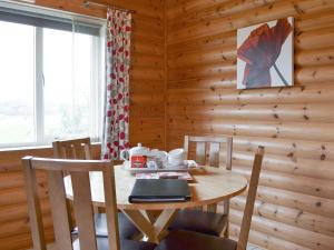 a wooden dining room with a table and chairs at Kingfisher Lodge- W43170 in Burn