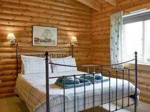 a bedroom with a bed in a log cabin at Kingfisher Lodge- W43170 in Burn