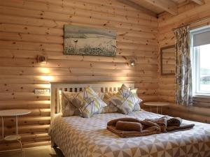 a bedroom with a bed in a wooden wall at Teal Lodge- Ukc2565 in Burn