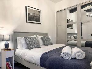 a bedroom with a bed with pillows on it at Coachmans Cottage in Settle