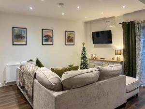 a living room with a couch and a christmas tree at Coachmans Cottage in Settle