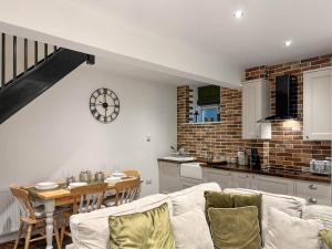 a kitchen and living room with a table and chairs at Coachmans Cottage in Settle +13 photos
