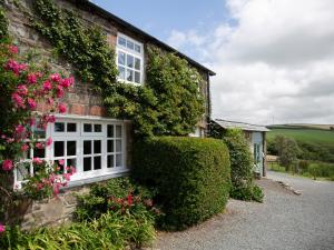 a house with flowers on the side of it at The Coach House - Ukc4691 in Kilkhampton +10 photos