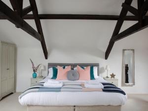 a bedroom with a large bed with colorful pillows at The Coach House - Ukc4691 in Kilkhampton