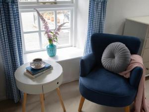 a blue chair and a table in a room with a window at The Coach House - Ukc4691 in Kilkhampton