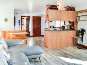 a living room with a couch and a kitchen at Maberry Cottage - Uk7784 in Newton Stewart