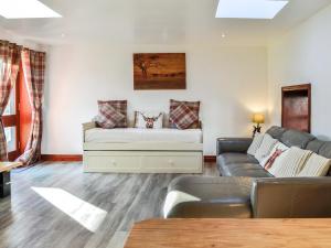 a living room with a couch and a table at Maberry Cottage - Uk7784 in Newton Stewart