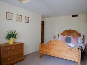 a bedroom with a wooden bed and a wooden dresser at Honeysuckle Cottage - Ukc4692 in Kilkhampton