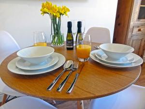 a wooden table with two bowls and two bottles of wine at Great Orme - Uk2775 in Llandudno