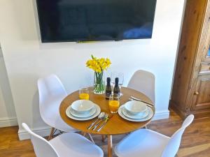 a dining room table with white chairs and a table with wine glasses at Great Orme - Uk2775 in Llandudno