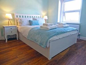 a bedroom with a bed with towels on it at Great Orme - Uk2775 in Llandudno +7 photos