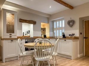 a kitchen with a table and chairs in a kitchen at Bailey Cottage in Skipton
