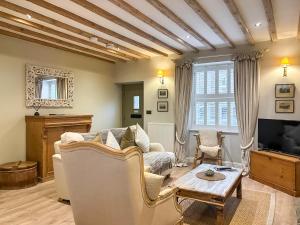 a living room with a couch and a tv at Bailey Cottage in Skipton