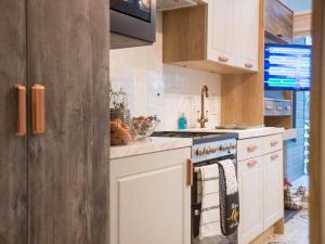 a kitchen with white cabinets and a stove top oven at Meadow Retreat - Ukc8192 in Dolau
