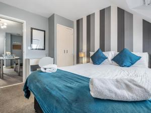 a bedroom with a large bed with blue pillows at Sandyford Apartment in Jesmond
