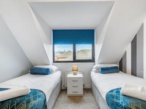 two twin beds in a room with a window at Sandyford Apartment in Jesmond