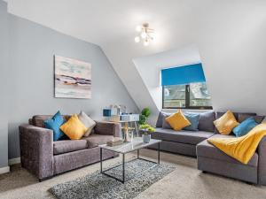 a living room with two couches and a table at Sandyford Apartment in Jesmond