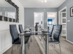 a dining room with a black table and black chairs at Sandyford Apartment in Jesmond +10 photos