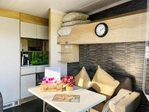 a living room with a table and a clock on a wall at The Foxes Den - Ukc8196 in Dolau