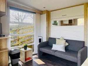 a living room with a couch and a large window at The Foxes Den - Ukc8196 in Dolau