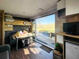 a living room with a table and a large window at The Foxes Den - Ukc8196 in Dolau