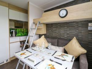 a room with a table and a clock on a wall at The Foxes Den - Ukc8196 in Dolau