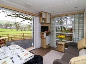 a living room with a table and a large window at The Foxes Den - Ukc8196 in Dolau +5 photos
