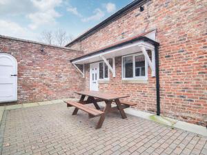 a wooden picnic table in front of a brick building at Cottage 2 - Ukc3179 in York