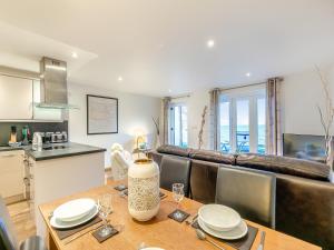 a kitchen and dining room with a table and a couch at 20 Mount Brioni in Downderry