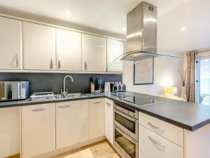 a kitchen with white cabinets and a sink at 20 Mount Brioni in Downderry