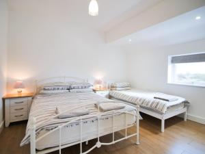 a white bedroom with two beds and a window at Cottage 8 - Ukc3185 in York