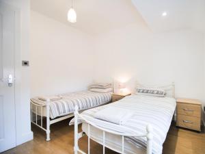 two beds in a room with white walls and wooden floors at Cottage 8 - Ukc3185 in York