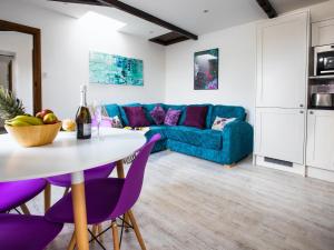 a living room with a blue couch and a table at Lavender Cottage - Ukc4695 in Kilkhampton