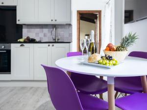 a white table with purple chairs and a plate of fruit at Lavender Cottage - Ukc4695 in Kilkhampton