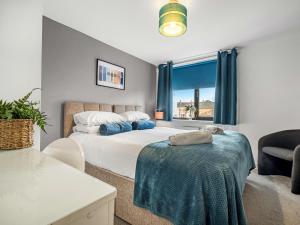 a bedroom with a bed and a chair and a window at Ouseburn Apartment in Jesmond