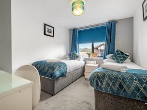 a bedroom with two beds and a window at Ouseburn Apartment in Jesmond