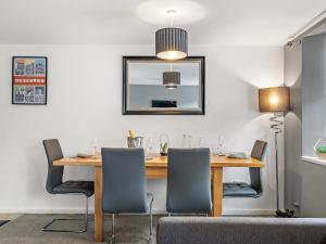 a dining room with a wooden table and chairs at Ouseburn Apartment in Jesmond +6 photos