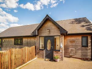 a log cabin with a black door and a fence at Caban Dulas - Ukc8195 in Dolau