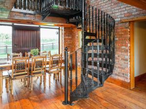 a dining room with a table and a brick wall at The Threshing Barn - Ukc8847 in Timberland