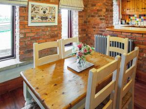 a wooden table with chairs and a vase of flowers at The Threshing Barn - Ukc8847 in Timberland