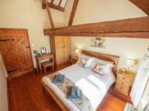 a bedroom with a large white bed with wooden floors at The Threshing Barn - Ukc8847 in Timberland