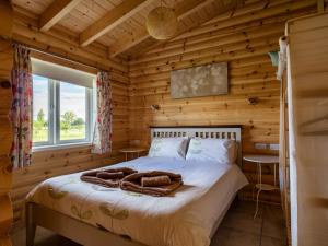 a bedroom with a bed in a log cabin at Quail Lodge - W44304 in Burn +5 photos