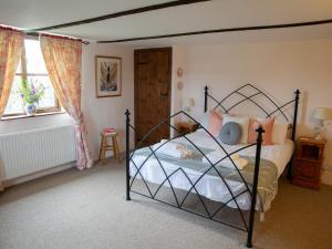 a bedroom with a black bed with a dog on it at Rose Cottage - Ukc4693 in Kilkhampton +14 photos
