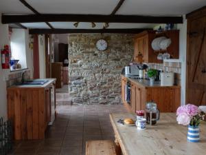 a kitchen with a table and a stone wall at Rose Cottage - Ukc4693 in Kilkhampton