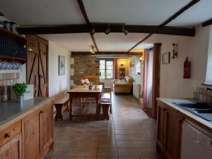 a kitchen with a table and a living room at Rose Cottage - Ukc4693 in Kilkhampton