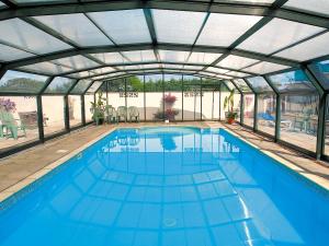 an indoor swimming pool with a glass roof at Fuchia in Marhamchurch