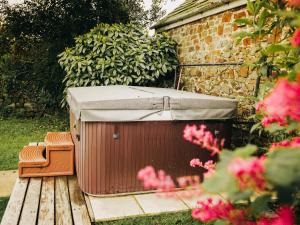 a hot tub with a canopy on a wooden deck at Fuchia in Marhamchurch
